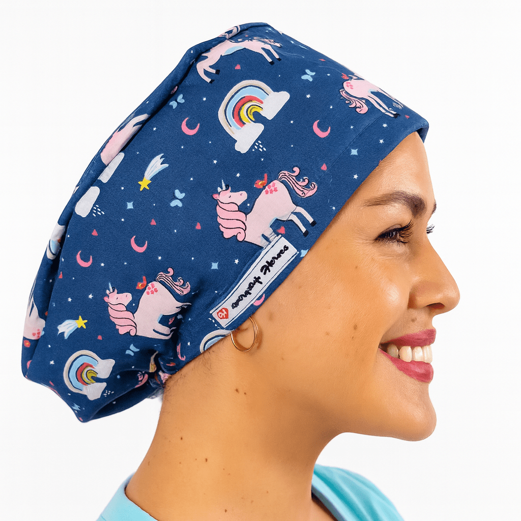 a woman wearing a scrub cap blue with pink unicorns on it and rainbows , the hat is cotton surgical cap euro style and can be embroideed with her name