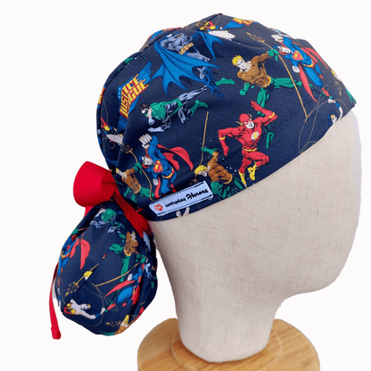 a mannequin head wearing a scrub cap ponytail for nurses ,with  avengers print  and a red ribbon i tie