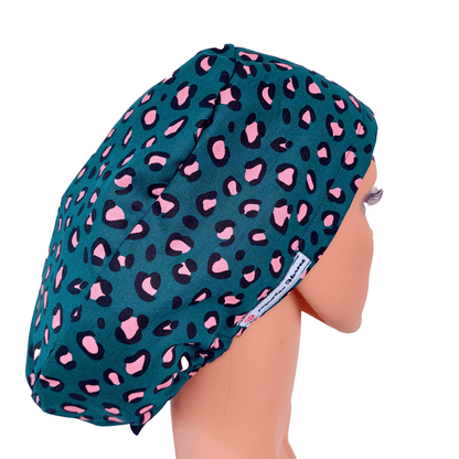 a mannequin doll head wearing a scrub cap leopard green with pink dots . 