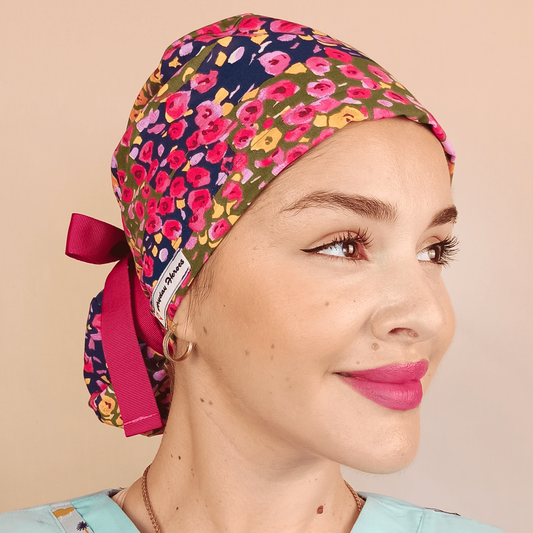 Floral custom satin lined scub cap for women pink ribbon for your ponytail at back, a nurse wearing and smilling this floral scrub cap