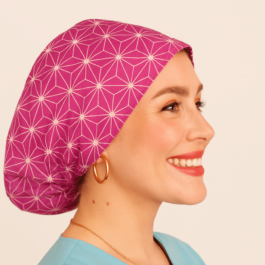 a woman wearing  apink scrub cap with abstract asanoha cotton print, the style is euro scrub hat its adjustable and she is smilling .