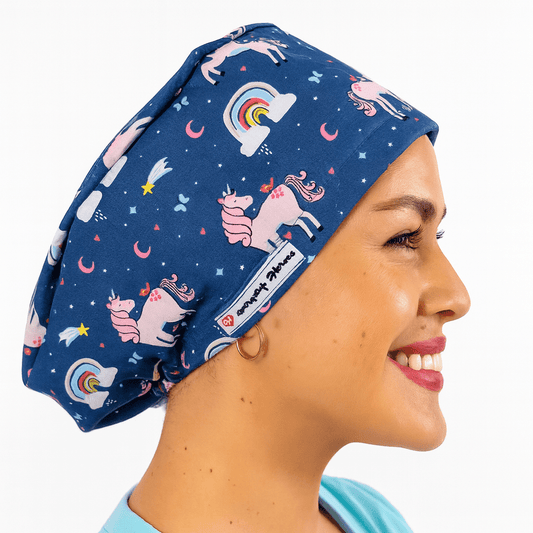 a woman wearing a scrub cap blue with pink unicorns on it and rainbows , the hat is cotton surgical cap euro style and can be embroideed with her name 